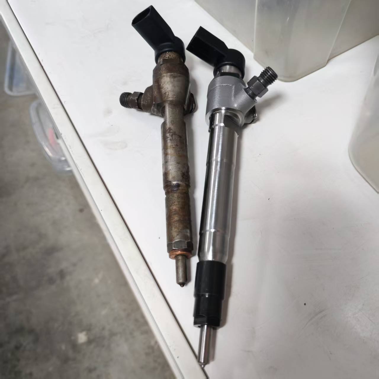 Siemens VDO diesel injector with a corroded used core beside a bright-finished unit
